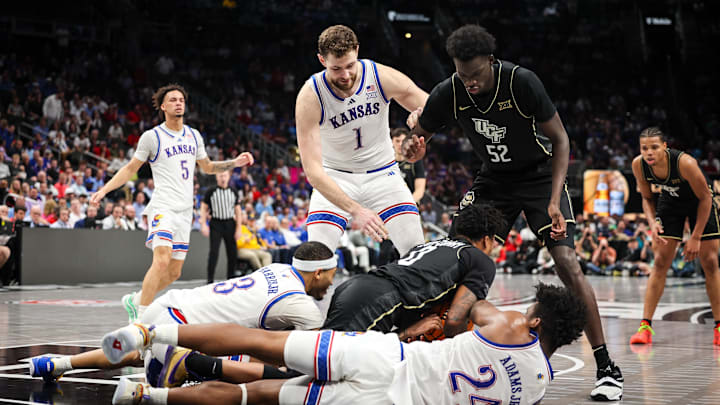 Mar 12, 2025; Kansas City, MO, USA; Kansas Jayhawks forward KJ Adams Jr. (24) and UCF Knights guard Jordan Ivy-Curry (0) go after a loose ball in overtime at T-Mobile Center. Mandatory Credit: William Purnell-Imagn Images