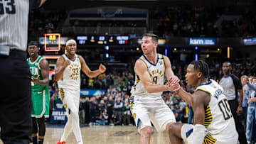 Jan 8, 2024; Indianapolis, Indiana, USA; Indiana Pacers guard T.J. McConnell (9) helps up Indiana Pacers guard Bennedict Mathurin (00) after a foul  in the second half against the Boston Celtics at Gainbridge Fieldhouse. Mandatory Credit: Trevor Ruszkowski-Imagn Images