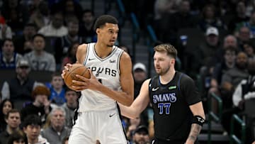 Feb 14, 2024; Dallas, Texas, USA; San Antonio Spurs center Victor Wembanyama (1) looks to move the ball past Dallas Mavericks guard Luka Doncic (77) during the fist quarter at the American Airlines Center. Mandatory Credit: Jerome Miron-Imagn Images