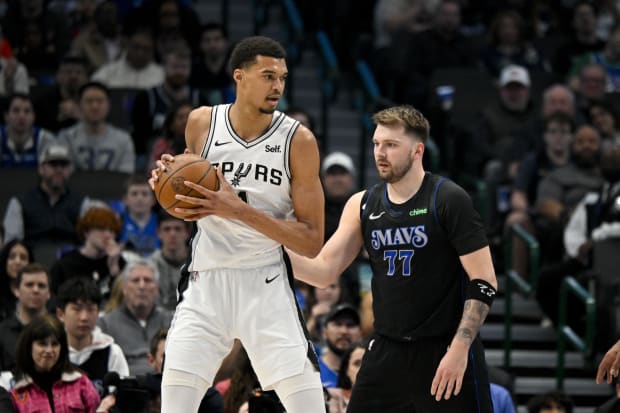 San Antonio Spurs center Victor Wembanyama (1) looks to move the ball past Dallas Mavericks guard Luka Doncic (77). 