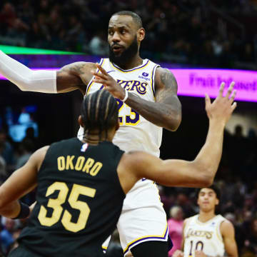 Nov 25, 2023; Cleveland, Ohio, USA; Los Angeles Lakers forward LeBron James (23) passes as Cleveland Cavaliers guard Donovan Mitchell (45) and forward Isaac Okoro (35) defend during the second half at Rocket Mortgage FieldHouse. Mandatory Credit: Ken Blaze-USA TODAY Sports