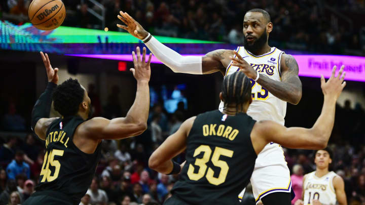 Nov 25, 2023; Cleveland, Ohio, USA; Los Angeles Lakers forward LeBron James (23) passes as Cleveland Cavaliers guard Donovan Mitchell (45) and forward Isaac Okoro (35) defend during the second half at Rocket Mortgage FieldHouse. Mandatory Credit: Ken Blaze-USA TODAY Sports