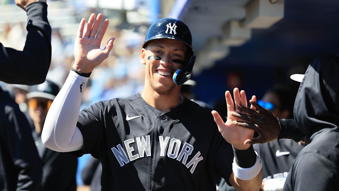 Feb 24, 2026; Dunedin, Florida, USA;  New York Yankees right fielder Aaron Judge (99) smiles as he high fives in the dugout after he scored a run during the first inning against the Toronto Blue Jays at TD Ballpark. Mandatory Credit: Kim Klement Neitzel-Imagn Images