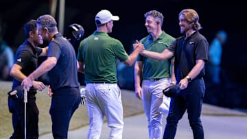 Tommy Fleetwood of Los Angeles Golf Club, right, Rory McIlroy and Adam Scott of Boston Common Golf and Justin Rose and Collin Morikawa greet each other at the end of their TGL golf match at the SoFi Center on February 4, 2025, in Palm Beach Gardens, Florida.