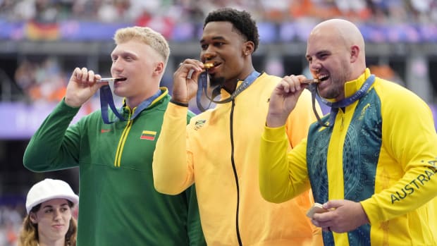 Mykolas Alekna, left, shows off his Olympic silver medal