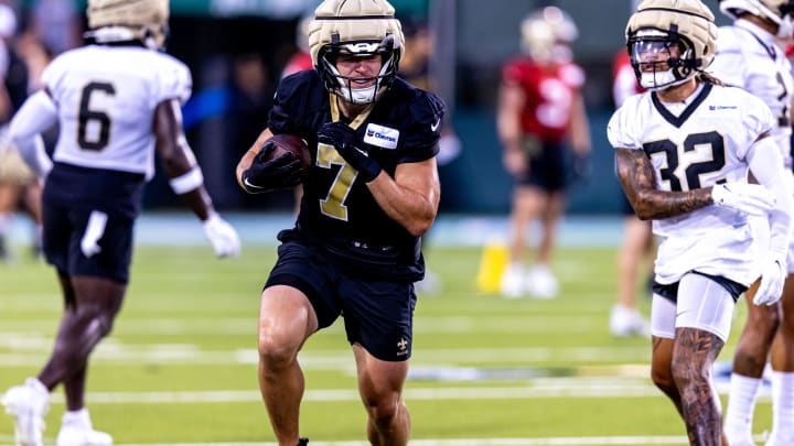 Aug 20, 2024; New Orleans, LA, USA;  New Orleans Saints quarterback Taysom Hill (7) runs away from the tackle of safety Tyrann Mathieu (32) during practice at Yulman Stadium (Tulane). Mandatory Credit: Stephen Lew-USA TODAY Sports