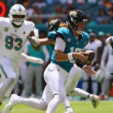 Sep 8, 2024; Miami Gardens, Florida, USA; Jacksonville Jaguars running back Travis Etienne Jr. (1) takes a handoff from quarterback Trevor Lawrence (16) against the Miami Dolphins during the first quarter  at Hard Rock Stadium. Mandatory Credit: Sam Navarro-Imagn Images