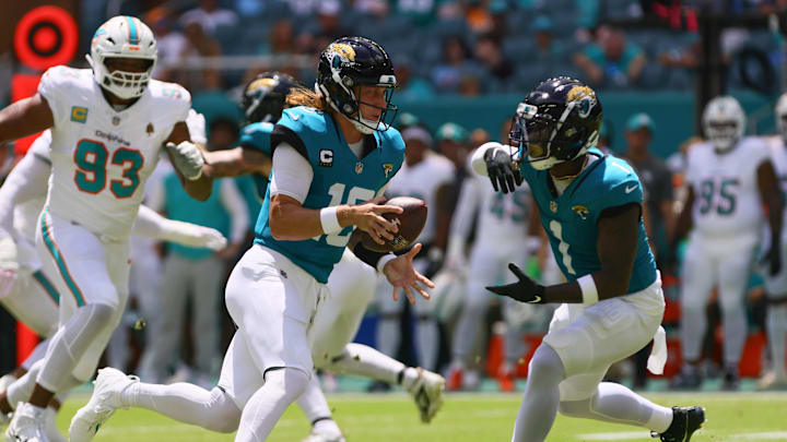 Sep 8, 2024; Miami Gardens, Florida, USA; Jacksonville Jaguars running back Travis Etienne Jr. (1) takes a handoff from quarterback Trevor Lawrence (16) against the Miami Dolphins during the first quarter  at Hard Rock Stadium. Mandatory Credit: Sam Navarro-Imagn Images