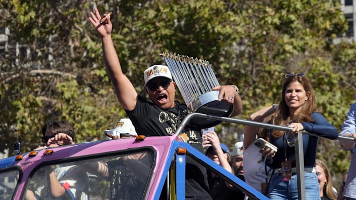 Los Angeles Dodgers manager Dave Roberts (30) celebrates with the Commissioner’s Trophy during the 2024 World Series championship parade near Los Angeles City Hall.
