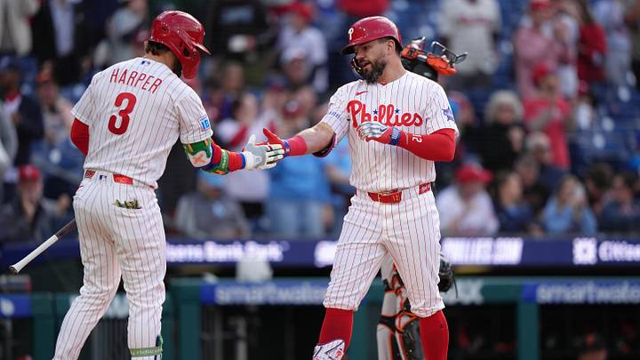 Philadelphia Phillies designated hitter Kyle Schwarber reacts with infielder Bryce Harper.