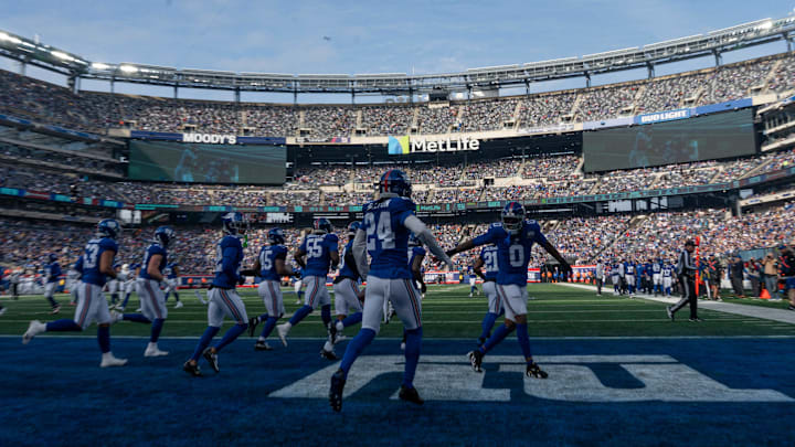 New York Giants linebacker Brian Burns (0) and New York Giants safety Dane Belton (24) celebrate after an interception during a game between New York Giants and Indianapolis Colts at MetLife Stadium on Sunday, Dec. 29, 2024.