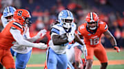 Oct 31, 2025; Syracuse, New York, USA; North Carolina Tar Heels running back Demon June (12) runs between Syracuse Orange linebacker David Reese (left) and linebacker Anwar Sparrow (12) in the third quarter at the JMA Wireless Dome. Mandatory Credit: Mark Konezny-Imagn Images