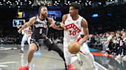 Toronto Raptors guard Ochai Agbaji dribbles the ball against Brooklyn Nets power forward Trendon Watford.