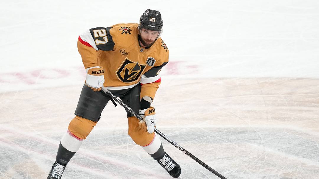 Jun 6, 2026; Las Vegas, Nevada, USA; Vegas Golden Knights defenseman Shea Theodore (27) passes the puck against the Carolina Hurricanes during the second period in game three of the 2026 Stanley Cup Final at T-Mobile Arena. Mandatory Credit: Lucas Peltier-Imagn Images