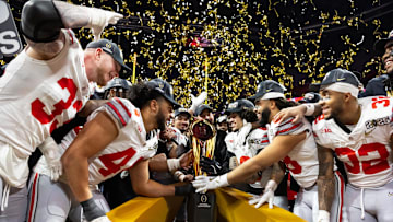 Jan 20, 2025; Atlanta, GA, USA; Ohio State Buckeyes defensive end Jack Sawyer (33), defensive end JT Tuimoloau (44), head coach Ryan Day, safety Lathan Ransom (8), tight end Gee Scott Jr. (88) and running back TreVeyon Henderson (32) celebrate with the trophy after defeating the Notre Dame Fighting Irish in the CFP National Championship college football game at Mercedes-Benz Stadium. Mandatory Credit: Mark J. Rebilas-Imagn Images