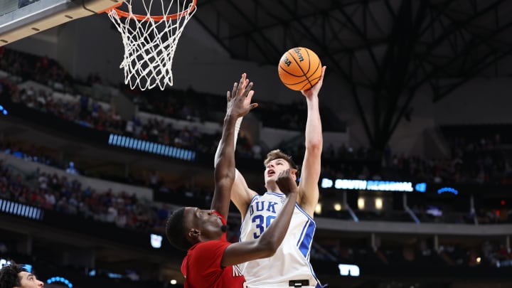 Mar 31, 2024; Dallas, TX, USA; Duke Blue Devils center Kyle Filipowski (30) shoots against North Carolina State Wolfpack forward Mohamed Diarra (23) in the second half in the finals of the South Regional of the 2024 NCAA Tournament at American Airline Center. Mandatory Credit: Tim Heitman-USA TODAY Sports