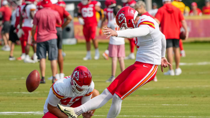 Jul 26, 2024; Kansas City, MO, USA; Kansas City Chiefs kicker Harrison Butker (7) kicks as punter Matt Araiza (49) holds during training camp at Missouri Western State University. Mandatory Credit: Denny Medley-USA TODAY Sports