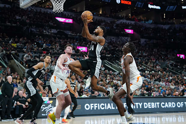 San Antonio Spurs guard Blake Wesley (14) goes up between Phoenix Suns forward Drew Eubanks (14) and center Bol Bol (11).