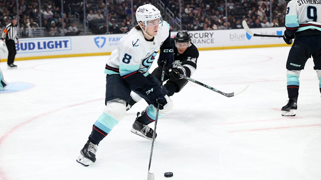 Apr 7, 2025; Los Angeles, California, USA;  Seattle Kraken defenseman Cale Fleury (8) skates with the puck against Los Angeles Kings left wing Trevor Moore (12) during the second period at Crypto.com Arena. Mandatory Credit: Kiyoshi Mio-Imagn Images