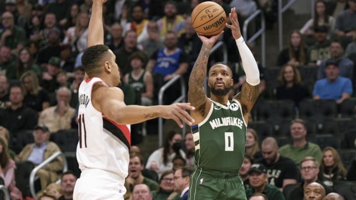 Nov 26, 2023; Milwaukee, Wisconsin, USA;  Milwaukee Bucks guard Damian Lillard (0) shoots against Portland Trail Blazers guard Malcolm Brogdon (11) during the first quarter at Fiserv Forum. Mandatory Credit: Jeff Hanisch-USA TODAY Sports