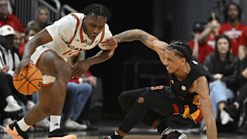 Feb 8, 2025; Louisville, Kentucky, USA;  Miami (Fl) Hurricanes guard Paul Djobet (10) dribbles against Louisville Cardinals forward Khani Rooths (9) during the second half at KFC Yum! Center. Louisville defeated Miami 88-78. Mandatory Credit: Jamie Rhodes-Imagn Images