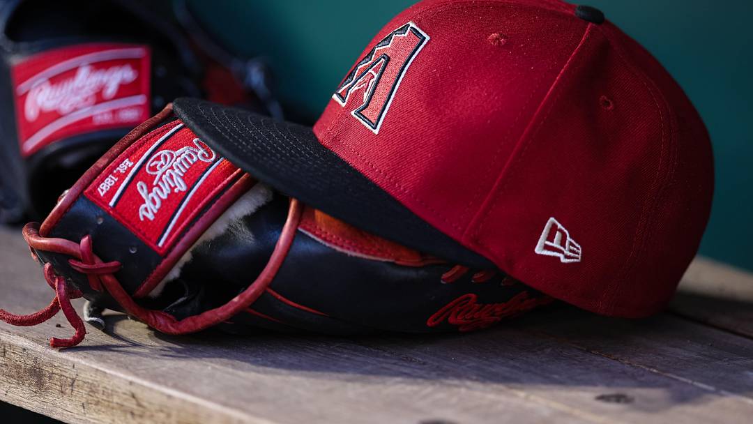 Jun 7, 2023; Washington, District of Columbia, USA; A general view of an Arizona Diamondbacks hat and Rawlings glove in the dugout during the fifth inning of the game against the Washington Nationals at Nationals Park. Mandatory Credit: Scott Taetsch-Imagn Images