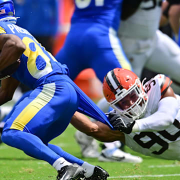 Aug 23, 2025; Cleveland, Ohio, USA; Cleveland Browns defensive end Joe Tryon-Shoyinka (90) grabs the jersey of Los Angeles Rams wide receiver Brennan Presley (81) during the first half at Huntington Bank Field. Mandatory Credit: Ken Blaze-Imagn Images