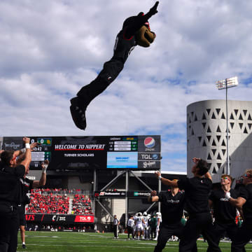 Oct 21, 2023; Cincinnati, Ohio, USA; The Cincinnati Bearcats mascot is thrown between cheerleaders in the first quarter at Nippert Stadium. Mandatory Credit: Kareem Elgazzar-USA TODAY Sports