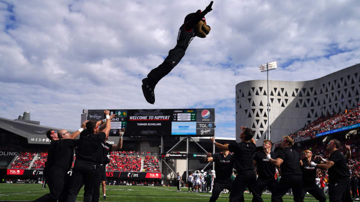 Oct 21, 2023; Cincinnati, Ohio, USA; The Cincinnati Bearcats mascot is thrown between cheerleaders in the first quarter at Nippert Stadium. Mandatory Credit: Kareem Elgazzar-USA TODAY Sports