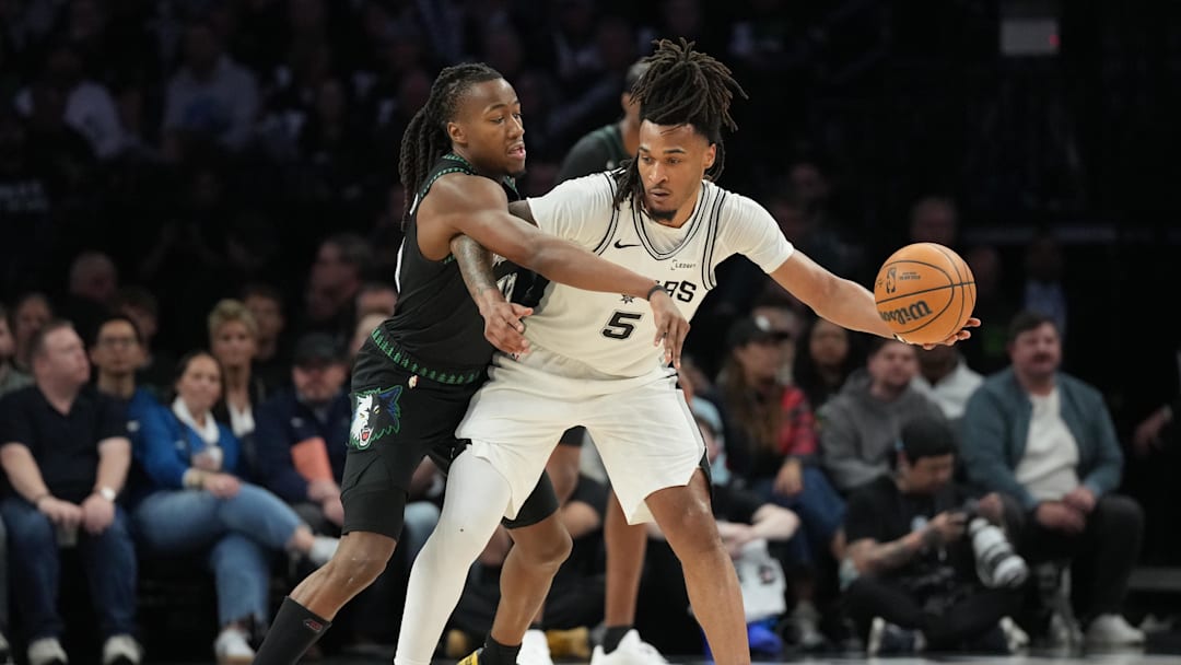 May 8, 2026; Minneapolis, Minnesota, USA; San Antonio Spurs guard Stephon Castle (5) holds the ball away from Minnesota Timberwolves guard Ayo Dosunmu (13) in the second half during game three of the second round of the 2026 NBA Playoffs at Target Center. Mandatory Credit: Jesse Johnson-Imagn Images