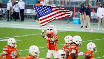 Nov 8, 2025; Miami Gardens, Florida, USA; Sebastian the Ibis waves the American flag as the Miami Hurricanes take the field before their game against the Syracuse Orange at Hard Rock Stadium. Mandatory Credit: Jeff Romance-Imagn Images