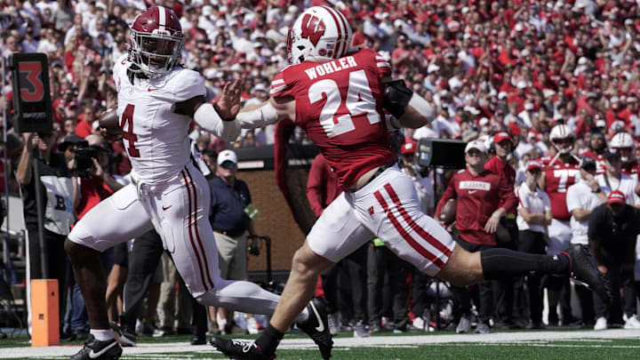 Sep 14, 2024; Madison, Wisconsin, USA; Alabama Crimson Tide quarterback Jalen Milroe (4) scores a touchdown in 10-yard run against Wisconsin Badgers safety Hunter Wohler (24) during the third quarter at Camp Randall Stadium. Alabama won 42-10. Mandatory Credit: Mark Hoffman/USA TODAY Network via Imagn Images