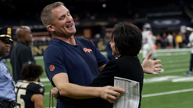 Denver Broncos special teams coordinator/assistant head coach Darren Rizzi greets New Orleans Saints owner Gayle Benson.
