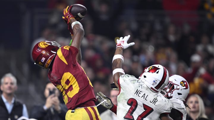 Dec 27, 2023; San Diego, CA, USA; USC Trojans wide receiver Ja'Kobi Lane (89) catches a touchdown pass over Louisville Cardinals defensive back Devin Neal (27) during the second half at Petco Park. Mandatory Credit: Orlando Ramirez-USA TODAY Sports