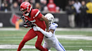 Nov 29, 2025; Louisville, Kentucky, USA;  Louisville Cardinals wide receiver Treyshun Hurry (2) tries to escape the tackle of Kentucky Wildcats defensive back Grant Grayton (30) during the first half at L&N Federal Credit Union Stadium. Mandatory Credit: Jamie Rhodes-Imagn Images