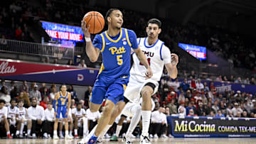 Feb 11, 2025; Dallas, Texas, USA; Pittsburgh Panthers guard Ishmael Leggett (5) passes the ball by Southern Methodist Mustangs center Samet Yigitoglu (24) during the first half at Moody Coliseum. Mandatory Credit: Jerome Miron-Imagn Images