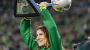 Oregon alum and New York Liberty player Sabrina Ionescu hoists the WNBA Finals trophy as the Oregon Ducks host the Maryland Terrapins at Autzen Stadium Saturday, Nov. 9, 2024 in Eugene, Ore.