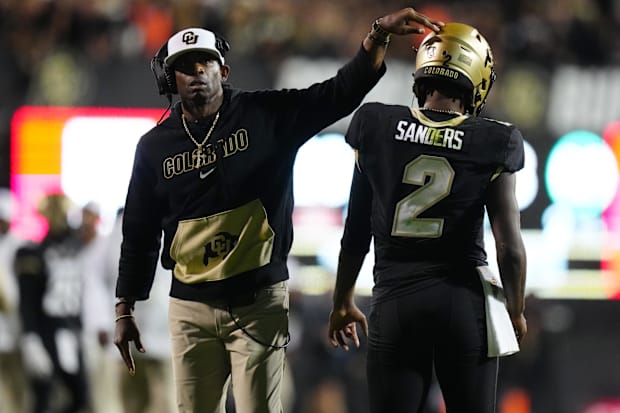 Sep 16, 2023; Boulder, Colorado, USA; Colorado Buffaloes quarterback Shedeur Sanders (2) and head coach Deion Sanders followi