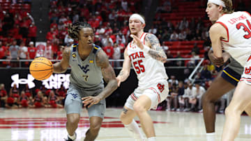 Mar 4, 2025; Salt Lake City, Utah, USA; West Virginia Mountaineers guard Javon Small (7) drives to the basket against Utah Utes guard Gabe Madsen (55) during the first half at Jon M. Huntsman Center. Mandatory Credit: Rob Gray-Imagn Images