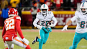 Jan 13, 2024; Kansas City, Missouri, USA; Miami Dolphins running back De'Von Achane (28) runs the ball against Kansas City Chiefs cornerback Trent McDuffie (22) during the second half of a 2024 AFC wild card game at GEHA Field at Arrowhead Stadium. Mandatory Credit: Jay Biggerstaff-Imagn Images