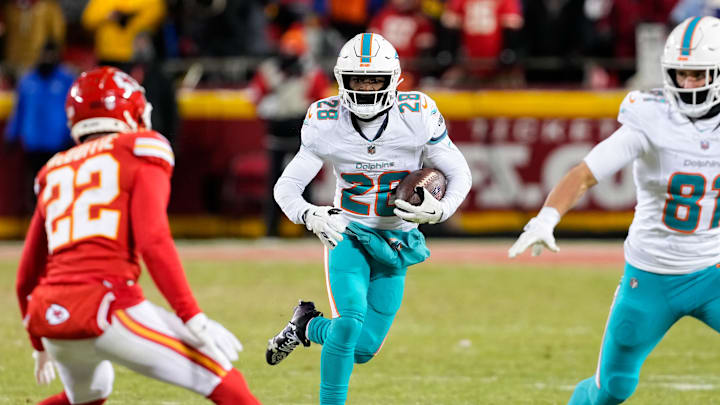 Jan 13, 2024; Kansas City, Missouri, USA; Miami Dolphins running back De'Von Achane (28) runs the ball against Kansas City Chiefs cornerback Trent McDuffie (22) during the second half of a 2024 AFC wild card game at GEHA Field at Arrowhead Stadium. Mandatory Credit: Jay Biggerstaff-Imagn Images