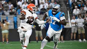 Aug 8, 2025; Charlotte, North Carolina, USA;  Cleveland Browns quarterback Shedeur Sanders (12) scrambles as Carolina Panthers defensive tackle Bobby Brown III (97) pressures in the second quarter at Bank of America Stadium. Mandatory Credit: Bob Donnan-Imagn Images