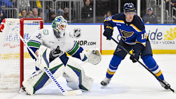 Jan 27, 2025; St. Louis, Missouri, USA;  Vancouver Canucks goaltender Kevin Lankinen (32) defends the net against St. Louis Blues center Radek Faksa (12) during the second period at Enterprise Center. Mandatory Credit: Jeff Curry-Imagn Images