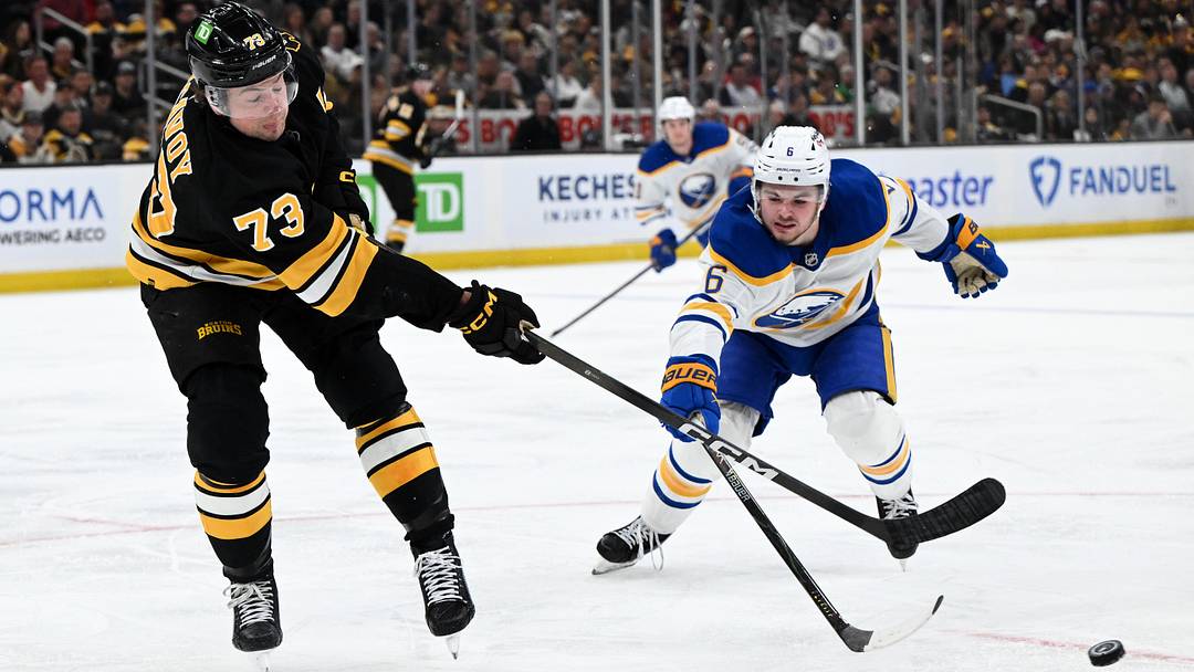 Apr 23, 2026; Boston, Massachusetts, USA; Boston Bruins defenseman Charlie McAvoy (73) clears the puck against Buffalo Sabres left wing Zach Benson (6) during the second period of game three of the first round of the 2026 Stanley Cup Playoffs at the TD Garden. Mandatory Credit: Brian Fluharty-Imagn Images