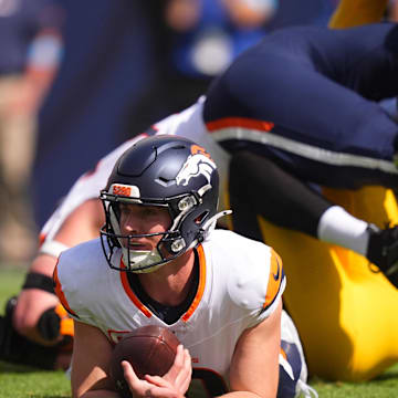 Sep 15, 2024; Denver, Colorado, USA; Denver Broncos quarterback Bo Nix (10) lays on the turf after a sack in the first quarter against the Pittsburgh Steelers at Empower Field at Mile High. Mandatory Credit: Ron Chenoy-Imagn Images