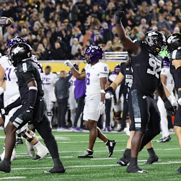 West Virginia University defensive lineman Asani Redwood (92) celebrates with linebacker Chase Wilson (30) against TCU.
