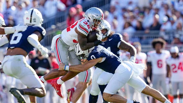 Ohio State Buckeyes running back TreVeyon Henderson (32) runs over Penn State Nittany Lions linebacker Dominic DeLuca (0) during the second half of the NCAA football game at Beaver Stadium in University Park, Pa. on Saturday, Nov. 2, 2024. Ohio State won 20-13.