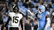 Nov 16, 2024; Chapel Hill, North Carolina, USA; North Carolina Tar Heels defensive lineman Travis Shaw (4) reacts after making a tackle as Wake Forest Demon Deacons quarterback Michael Kern (15) looks to the sideline in the third quarter at Kenan Memorial Stadium. 