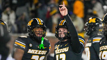Nov 30, 2024; Columbia, Missouri, USA; Missouri Tigers quarterback Brady Cook (12) celebrates with running back Jamal Roberts (20) after scoring the game-winning touchdown against the Arkansas Razorbacks during the first half at Faurot Field at Memorial Stadium. Mandatory Credit: Denny Medley-Imagn Images