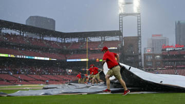 May 4, 2024; St. Louis, Missouri, USA;  St. Louis Cardinals grounds crew pulls the tarp on the field